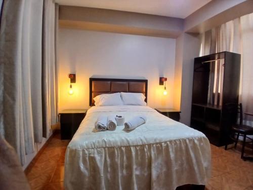 a bedroom with a large bed with shoes on it at Hotel Residencial San Isidro in Hualmay