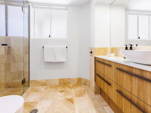 a bathroom with a sink and a toilet at Mantra Zanzibar in Mooloolaba