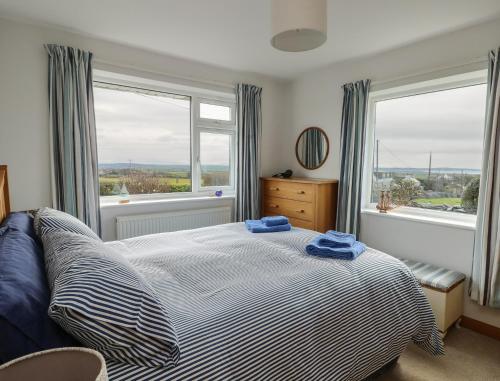 a bedroom with a bed with two blue towels on it at Yr Orsedd in Holyhead