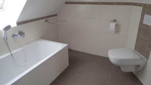 a bathroom with a tub and a toilet and a sink at Haus Phil in Lenz