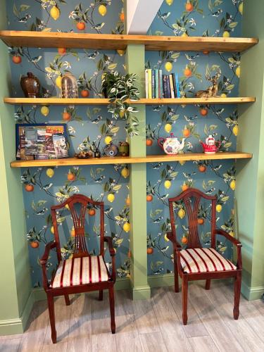two chairs in front of a book shelf with oranges at Hartoft House, 3 Bed, Near River and City in York
