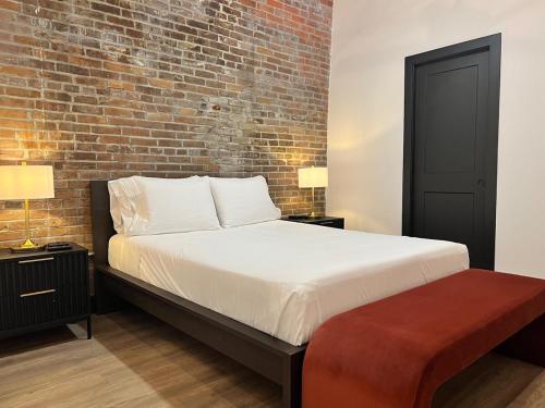 a bedroom with a bed with a brick wall at Brick & Bed Riverfront Lofts, T 410 in Saint Louis