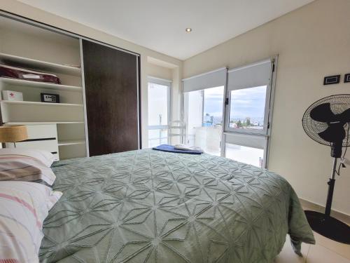 a bedroom with a large bed and a large window at Brisa Austral Comodoro in Comodoro Rivadavia