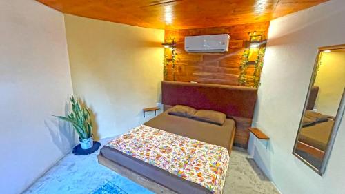 a small room with a bed and a mirror at Mr Pakal Tulum in Tulum
