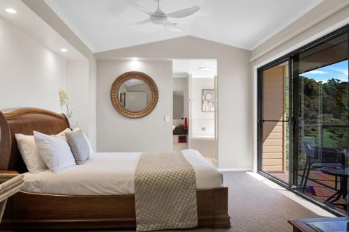 a bedroom with a bed and a mirror on the wall at Top Of The Hill in Maleny