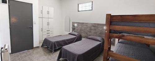 a room with two beds and a dresser in it at new bv carlos paz in Villa Carlos Paz