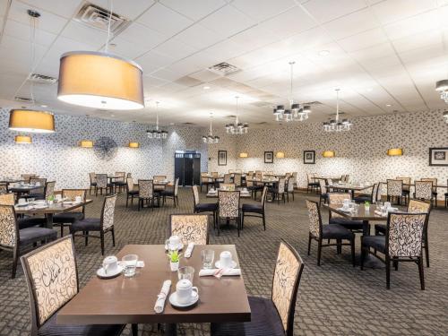 a dining room with tables and chairs in a restaurant at Crowne Plaza Milwaukee Airport by IHG in Milwaukee