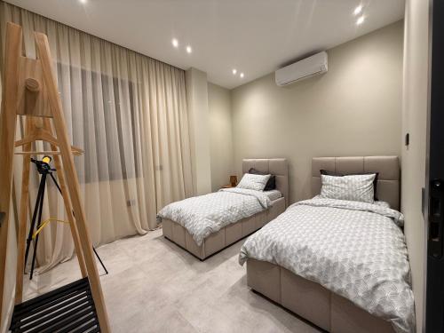 a bedroom with two beds and a tripod at Vog Villa in Tirana