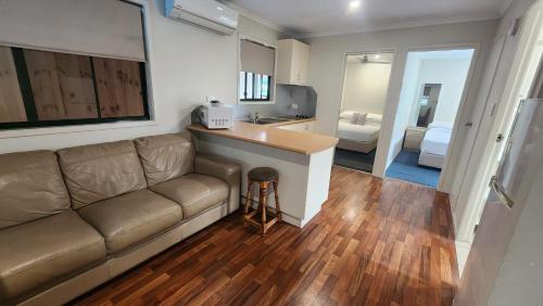 a living room with a couch and a kitchen at T's Resort & Motel in Port Macquarie