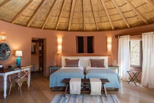a bedroom with two beds and a wooden ceiling at Awasi Atacama in San Pedro de Atacama