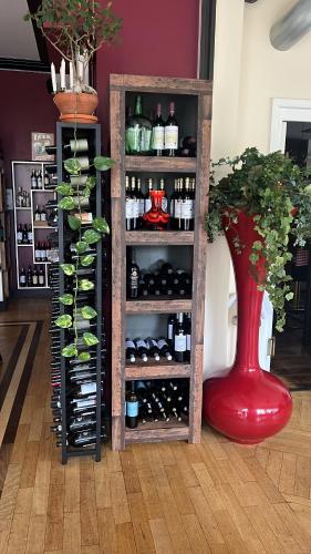 a shelf of wine bottles and a red vase at Hotel Belvedere in Seevetal