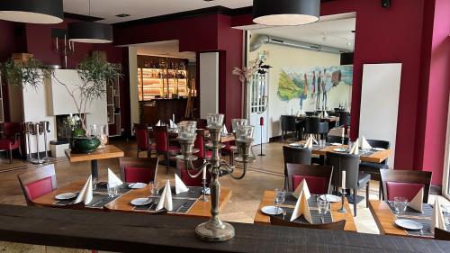 a dining room with tables and chairs and purple walls at Hotel Belvedere in Seevetal