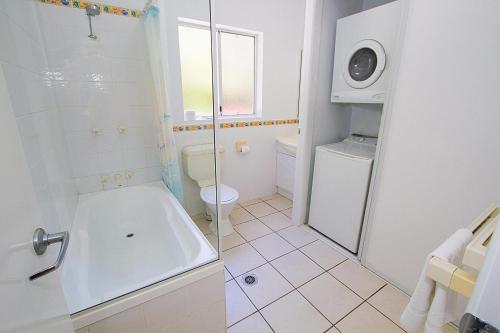 a bathroom with a tub and a toilet and a shower at Breakaway • Central Studio for 4 • Beach • Pool in Agnes Water