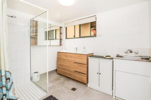 a white bathroom with a sink and a shower at Merindah • Pet-Friendly • Central 4BDR for 10 in Agnes Water