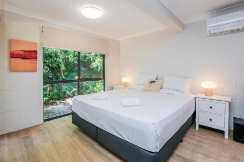a bedroom with a large bed and a window at Merindah • Pet-Friendly • Central 4BDR for 10 in Agnes Water