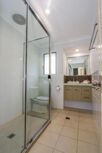 a bathroom with a glass shower and a toilet at McLeods • Pet-Friendly Central Beach House for 6 in Agnes Water