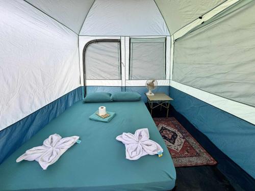 a blue bed in a tent with a candle on it at Teteng's Apartelle in San Vicente