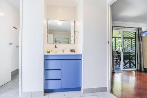 a bathroom with a blue sink and a mirror at On Agnes Time • Beach House for 10 • BBQ Deck • Walk to Beach in Agnes Water
