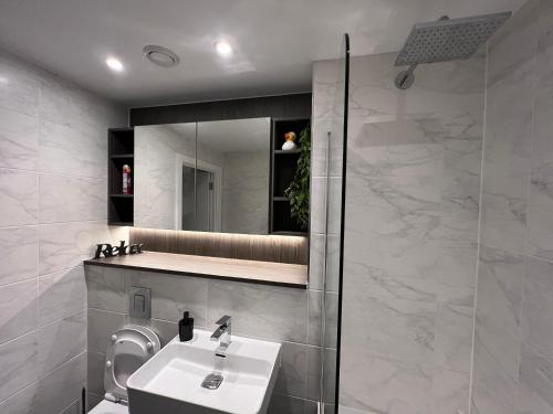 a bathroom with a sink and a mirror at Luxe Penthouse 2 bed Deansgate in Manchester