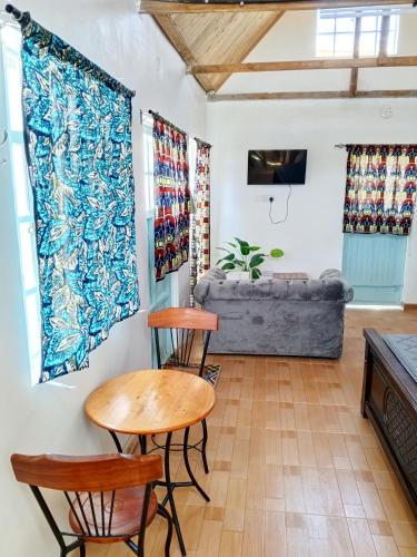 a living room with a table and chairs and a couch at Longonot Cabin in Longonot