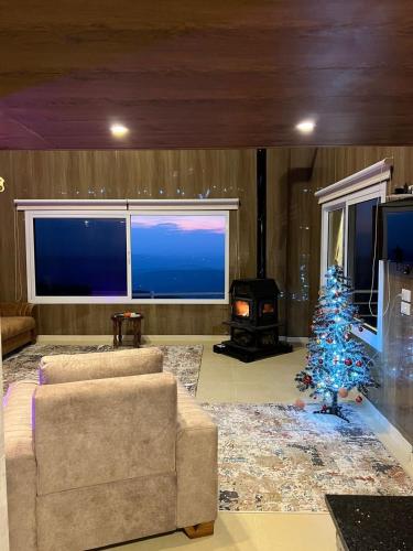 ein Wohnzimmer mit einem Weihnachtsbaum und einem Sofa in der Unterkunft Aroma Chalet in Ḩūmīn al Fawqā