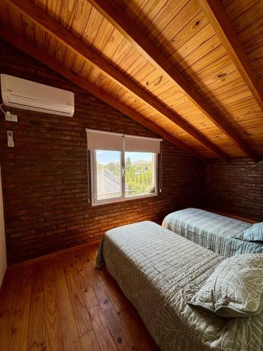 a bedroom with two beds in a room with a window at Lirios del Cerro in Sierra de la Ventana