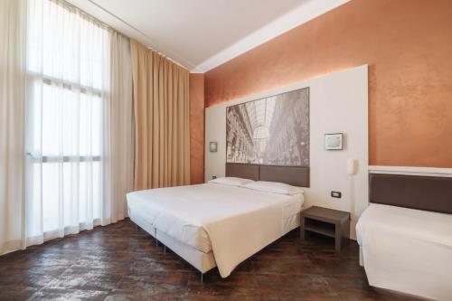 a bedroom with a bed and a large window at Hotel Milano Navigli in Milan