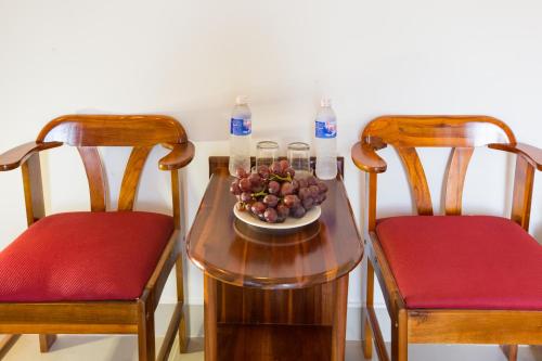 a table with a bowl of fruit and two chairs at Quynh Chau Homestay Hội An in Hoi An