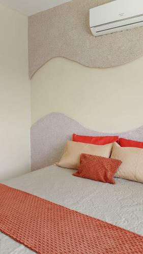 a bedroom with a bed with pillows on it at Casa Sol in Cabo de Santo Agostinho