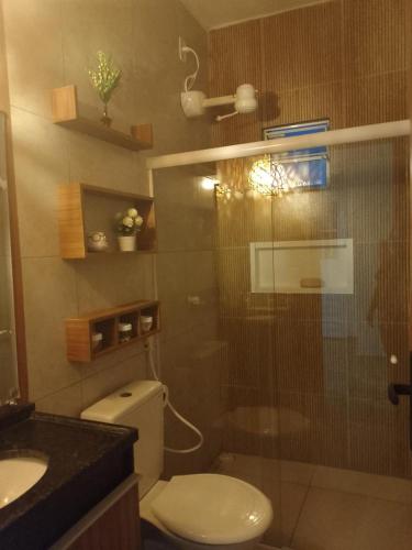 a bathroom with a toilet and a glass shower at Casa Sol in Cabo de Santo Agostinho