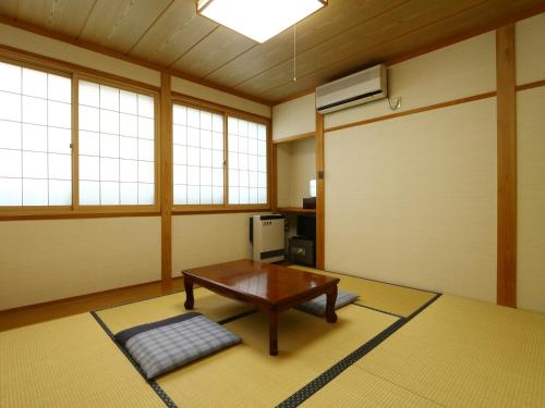 sala de estar con mesa y puerta en Mominoki, en Nozawa Onsen