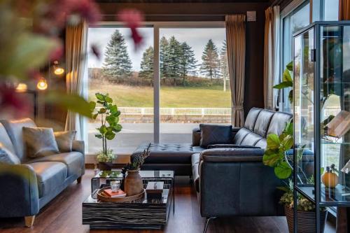 a living room with couches and a large window at The Horizon Residence in Makubetsu