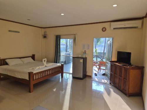 a bedroom with a bed and a television in it at Happy Mind Resort in Sam Roi Yot