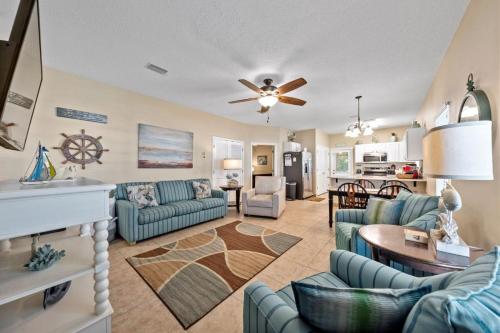 a living room with blue couches and a kitchen at Orange Beach Villas - Casa Bella by Youngs Suncoast in Orange Beach