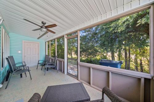 a screened in porch with a ceiling fan and chairs at Orange Beach Villas - Casa Bella by Youngs Suncoast in Orange Beach