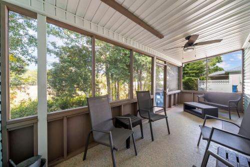 a screened in porch with chairs and windows at Orange Beach Villas - Casa Bella by Youngs Suncoast in Orange Beach