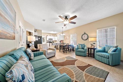 a living room with a couch and chairs and a kitchen at Orange Beach Villas - Casa Bella by Youngs Suncoast in Orange Beach