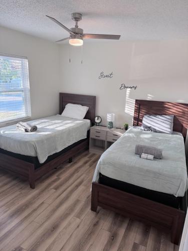 a bedroom with two beds and a ceiling fan at Tampa Bays Hidden Gem in Tampa
