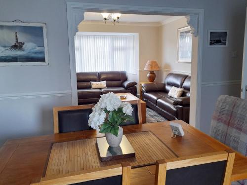 a living room with a table with flowers on it at Wheelhouse 21 in Amble
