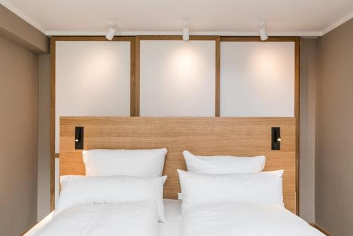 ein Schlafzimmer mit zwei Betten und weißen Kissen in der Unterkunft Green Kööv in Wenningstedt-Braderup