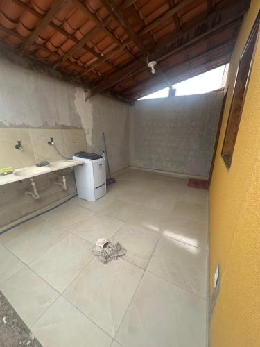 an empty room with a counter and a refrigerator at Casa Amarela no Fortim in Fortim