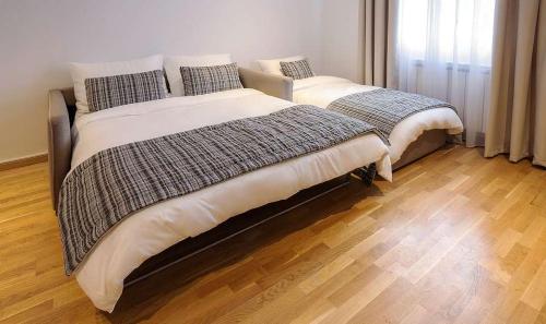 two beds sitting next to each other in a bedroom at Apartman Jelka Brzece in Brzeće