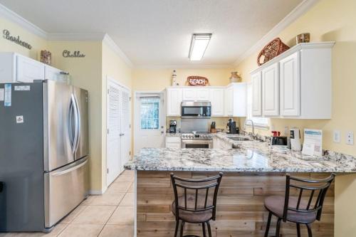 a kitchen with a stainless steel refrigerator and a counter at Orange Beach Villas - Serendipity in Orange Beach