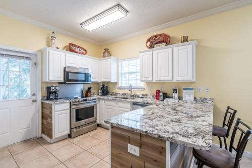 a kitchen with white cabinets and a marble counter top at Orange Beach Villas - Serendipity in Orange Beach