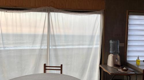sypialnia z łóżkiem i oknem z widokiem na ocean w obiekcie Cabaña Estela w mieście De Cauquenes