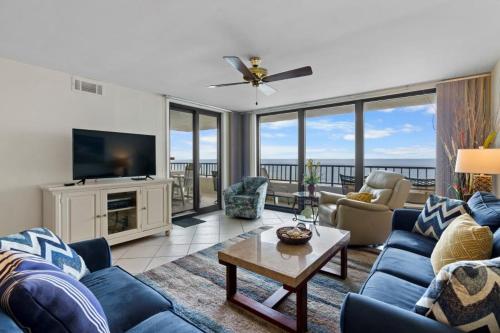 a living room with blue couches and a television at Perdido Quay 501 by Youngs Suncoast in Orange Beach