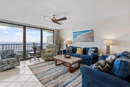 a living room with blue furniture and a balcony at Perdido Quay 501 by Youngs Suncoast in Orange Beach