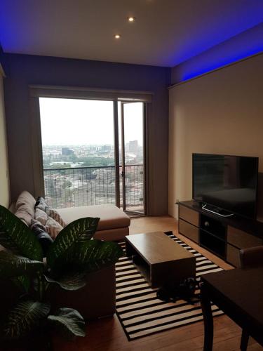 a living room with a large window and a television at CoLiving Suite, Arquitectura & Vista Premium in Mexico City