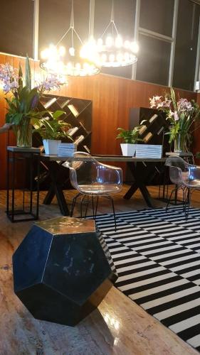 a room with two tables and chairs and plants at CoLiving Suite, Arquitectura & Vista Premium in Mexico City