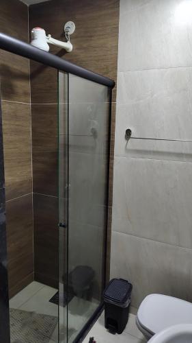 a bathroom with a glass shower with a toilet at Calmaria in Arraial do Cabo